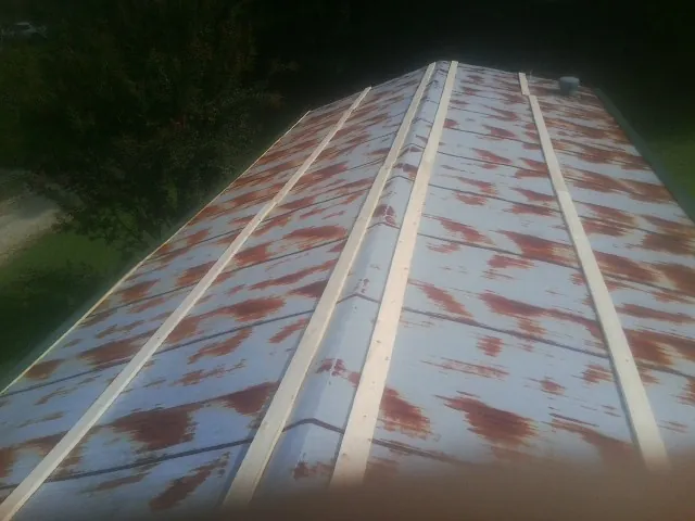 Rusted metal roof panels with new wood purlins before replacement — Storm Damage Roof Repair in Newcomb by Roofing Brothers