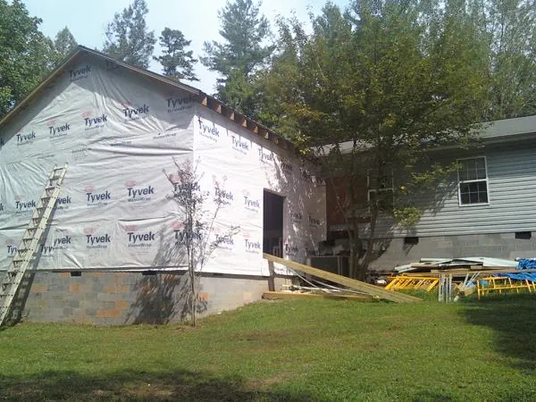 Tyvek wrapped gable on a new room addition beside an existing home in Newcomb