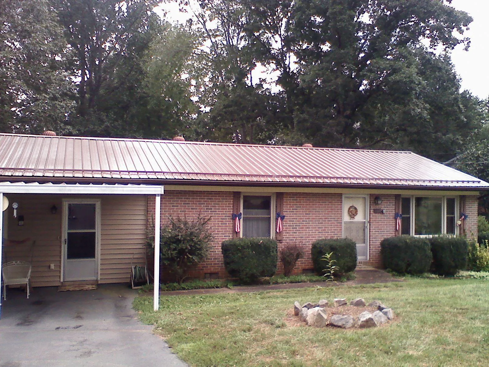 Bronze metal roof and carport on a brick ranch home — Roof Repair work by our crew in Newcomb